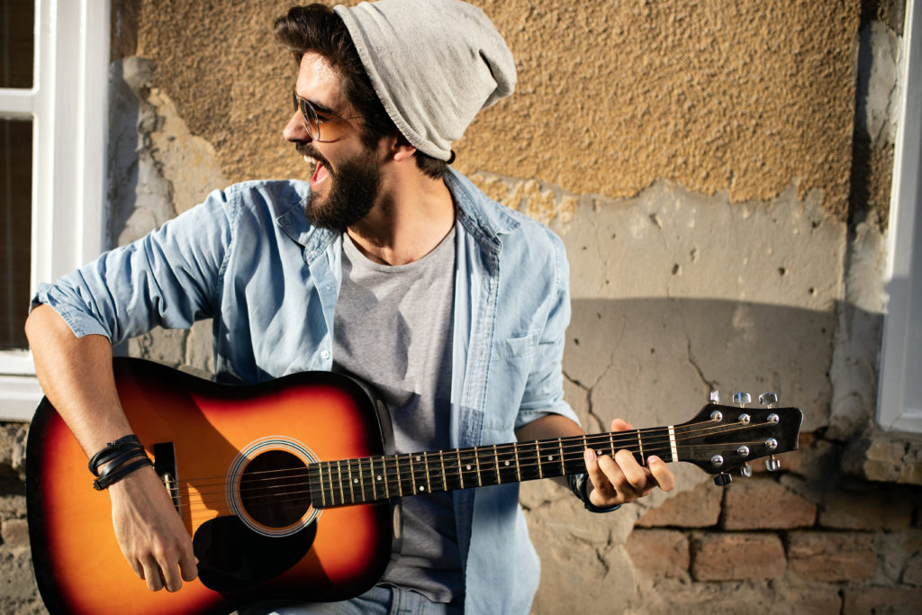 Young musician man with guitar in city